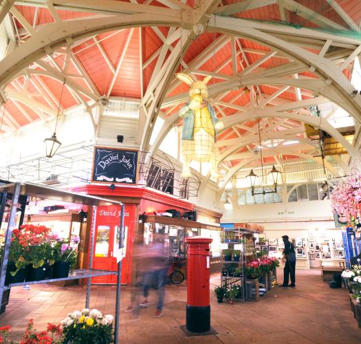 An image of the covered market in Oxford, with a red postbox in the middle
