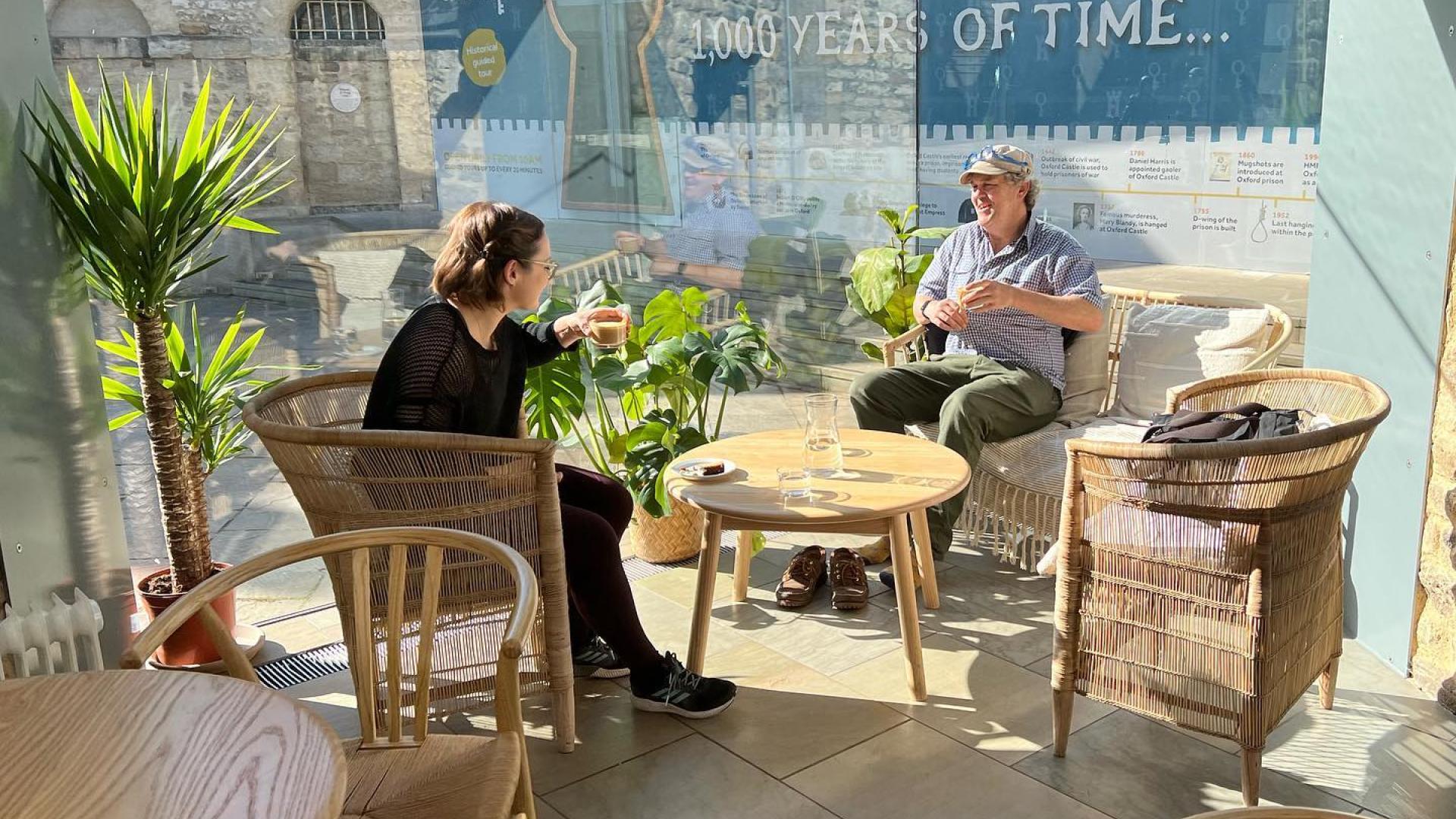 Two people sitting drinking coffee at Oxford Castle Cafe