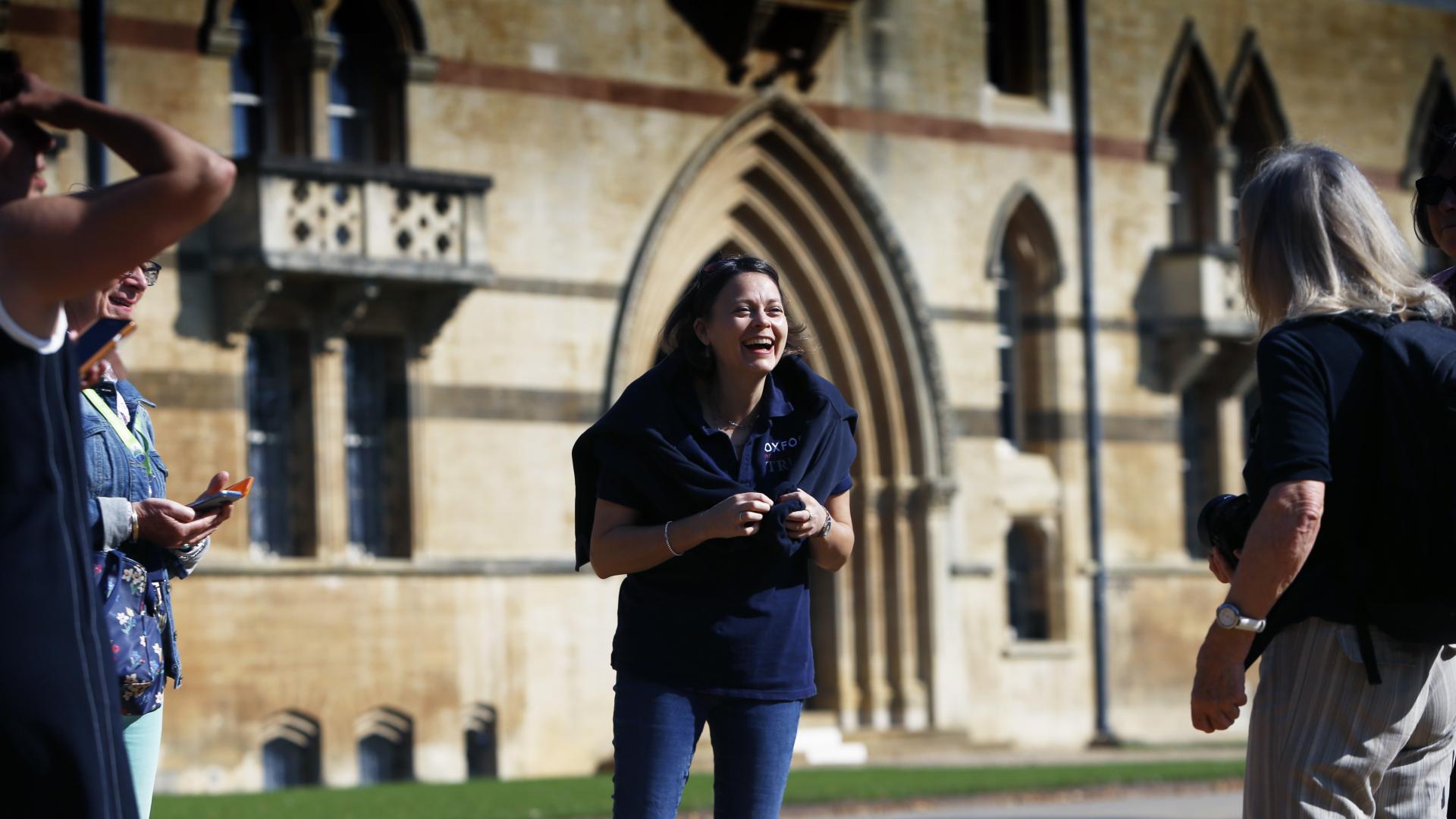 A person in a blue polo standing in front of Christ Church College