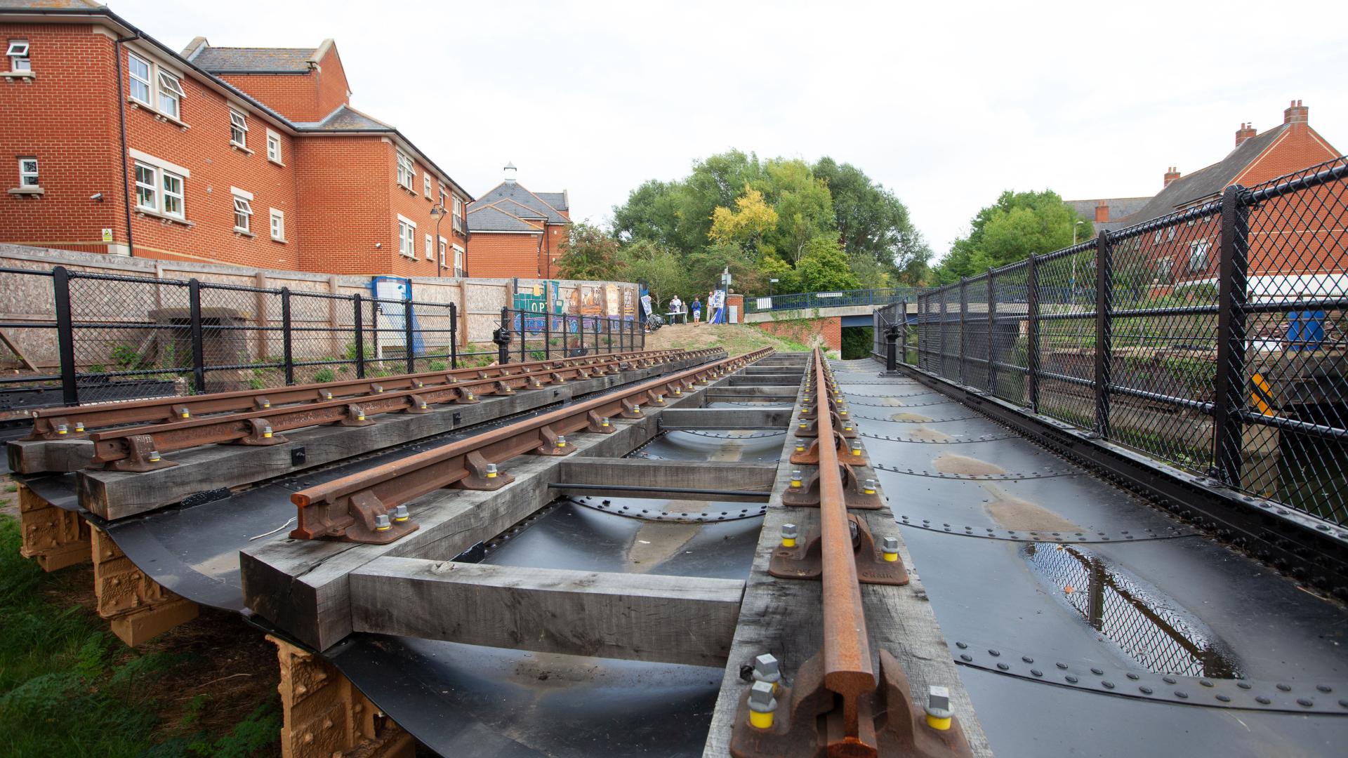 Close up of swing bridge with houses in background