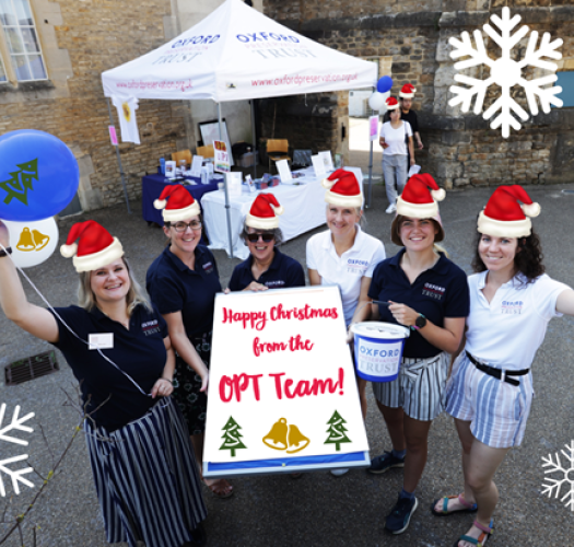 OPT team holding up balloons and wearing christmas hats