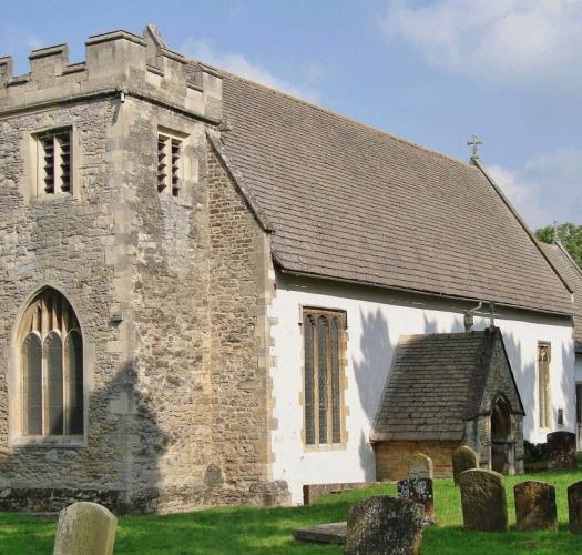 A church with a stone tower and white walls.