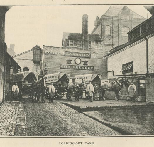 A black and white photograph of a brick brewery building and a yard filled with horses and carts and their drivers. The brewery's sign reads C. A. Hanley City Brewery 