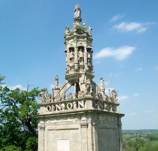 A stone conduit cover with ornate sculptural detail, including statues and the lettering O N O N.