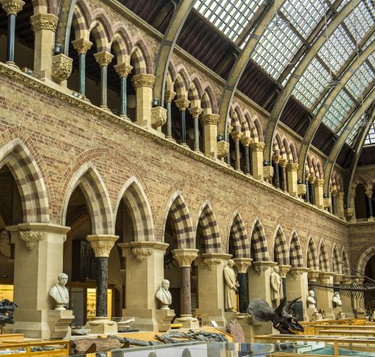 The interior of a Victorian brick building with striped arches and an ironwork roof.