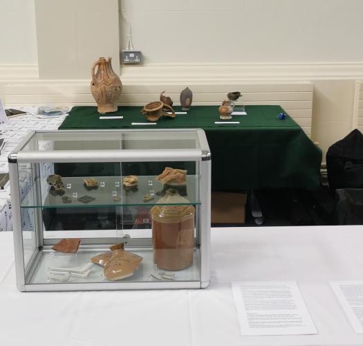 A table with Oxford Archaeology branding and a clear case containing pottery fragments.