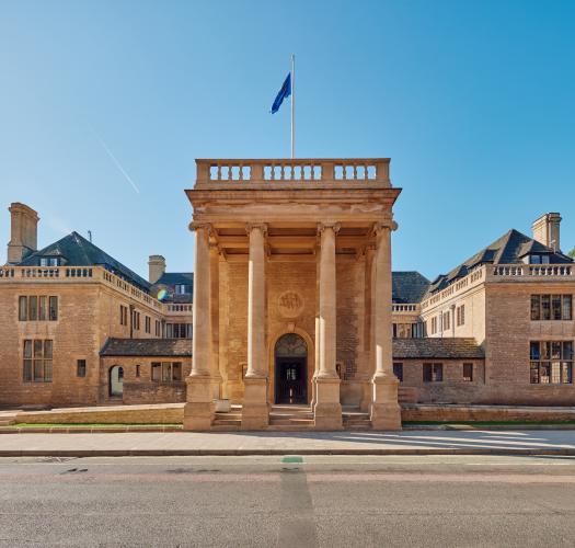 A large stone building with two wings and a central columned entrance.