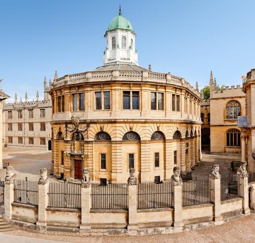 A semicircular stone building with a cupola with a green copper roof.