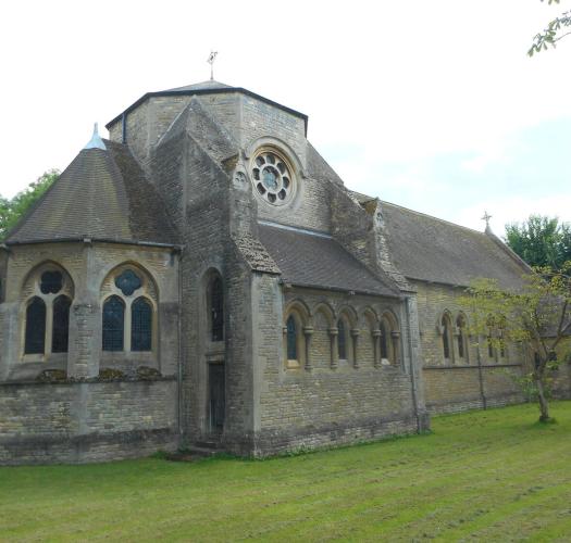 The exterior of a brick-built church in a grassy churchyard.