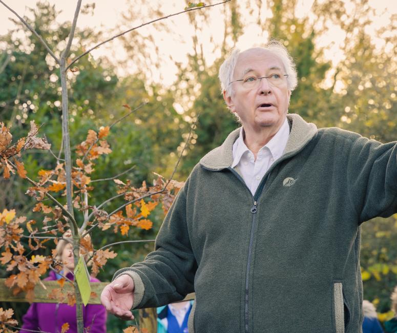 Philip Pullman with tree and children in the background