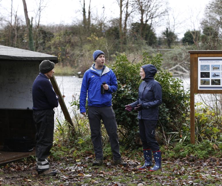 A group of people drinking coffee standing in a field