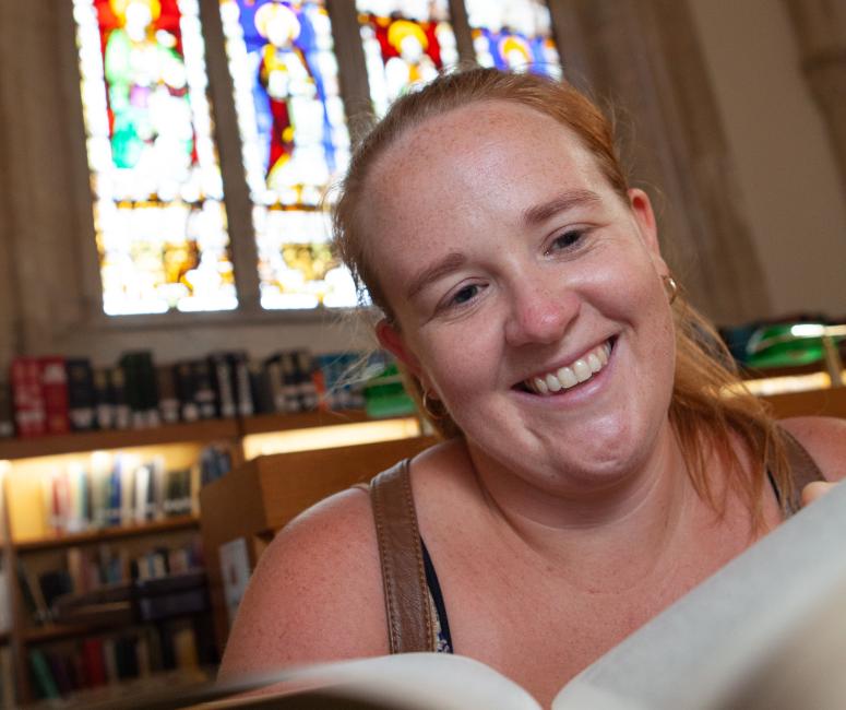 A person reading a book and smiling