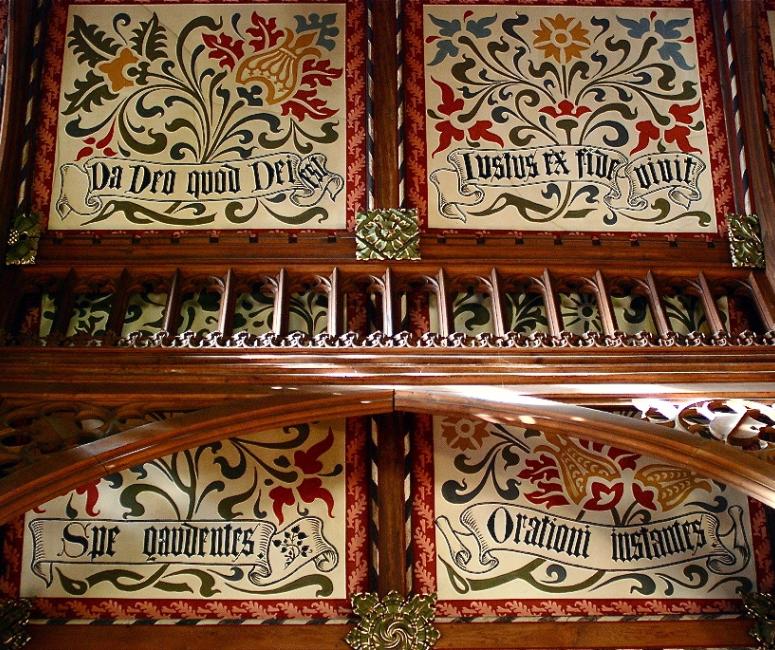 A wooden ceiling with ornate floral paintings.