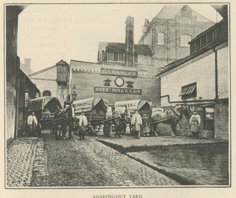 A black and white photograph of a brick brewery building and a yard filled with horses and carts and their drivers. The brewery's sign reads C. A. Hanley City Brewery 
