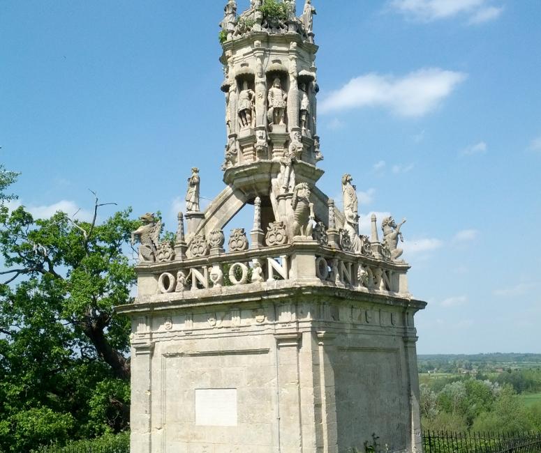 A stone conduit cover with ornate sculptural detail, including statues and the lettering O N O N.