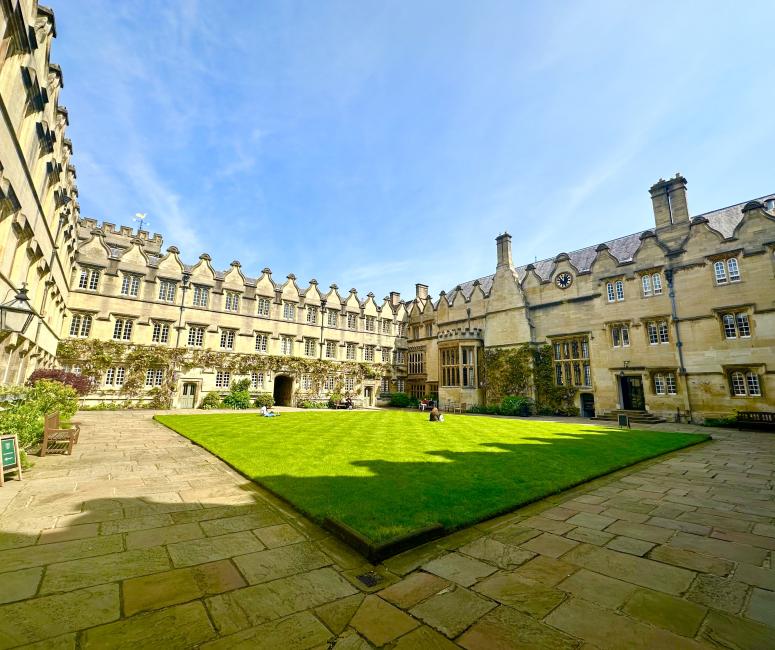 A grassy quadrangle surrounded by large stone buildings.