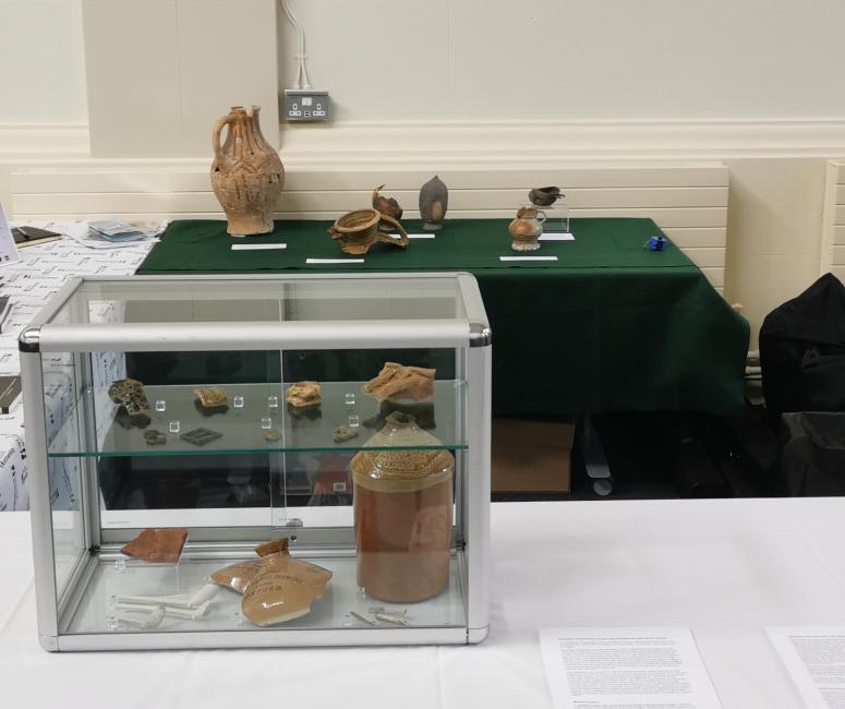 A table with Oxford Archaeology branding and a clear case containing pottery fragments.