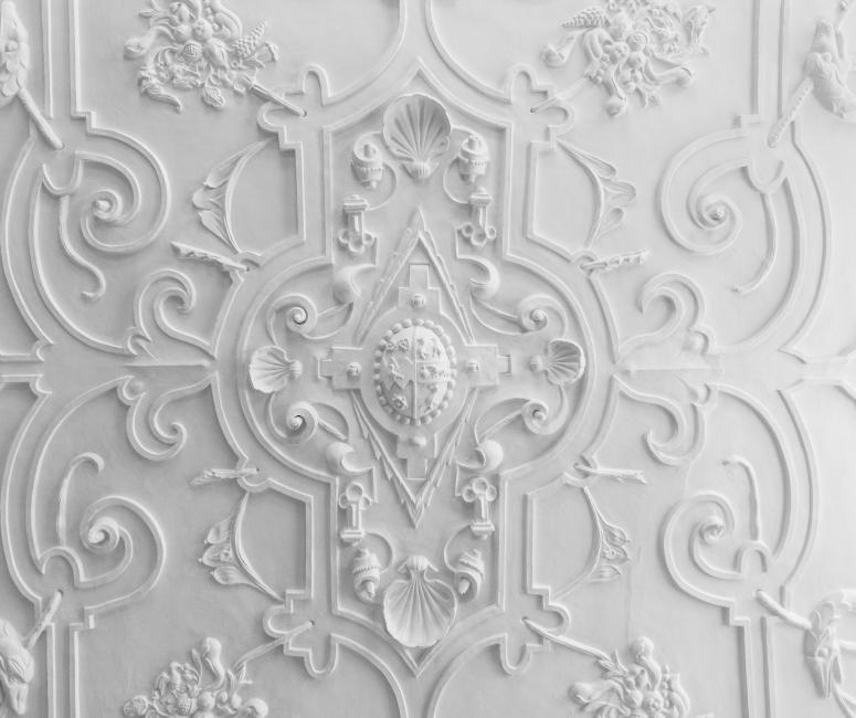 An ornate white plaster ceiling.