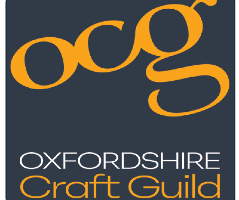 A square grey logo with a yellow title reading O C G, Oxfordshire Craft Guild.