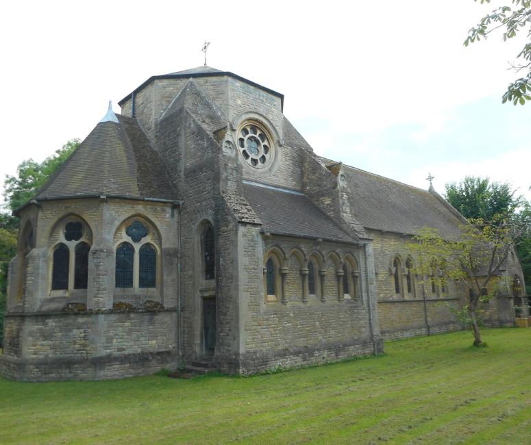 The exterior of a brick-built church in a grassy churchyard.
