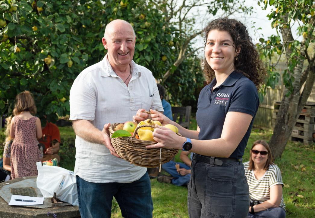 A young women receiving a basket of apples